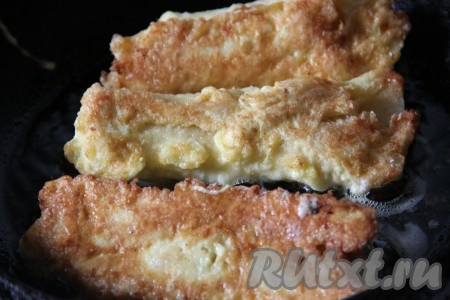 Обжарить хлебные рулетики на сковороде на разогретом растительном масле со всех сторон до золотистого цвета.