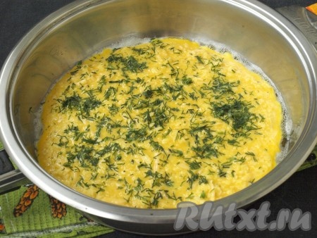 Разогреть в сковороде подсолнечное масло, вылить подготовленную смесь и сразу разровнять поверхность. Посыпать омлет сверху измельчённым укропом. Прикрыть сковороду крышкой, уменьшить огонь и готовить омлет 10 минут.
