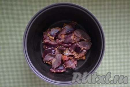 Куриные желудки и сердца хорошо вымыть, несколько раз меняя воду. Желудки разрезать на 2-3 части. Сложить в чашу мультиварки. 