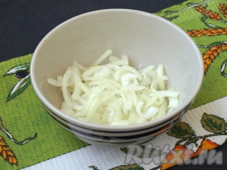 Приготовление начнём с маринования лука: очищенный лук, нарезанный полукольцами, залить кипятком на пару минут, затем выложить в сито и промыть холодной водой. Далее выложить лук в небольшую ёмкость, добавить сахар и уксус, перемешать и оставить мариноваться на 25-30 минут.