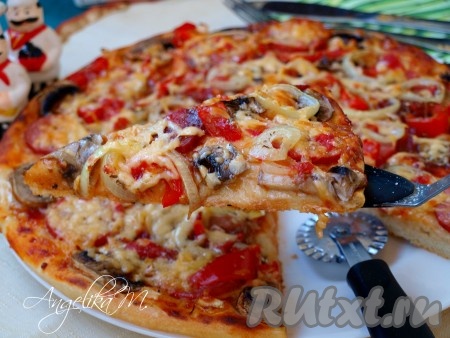 Горячую пиццу с колбасой и шампиньонами подавать сразу, разрезая на желаемые кусочки.
