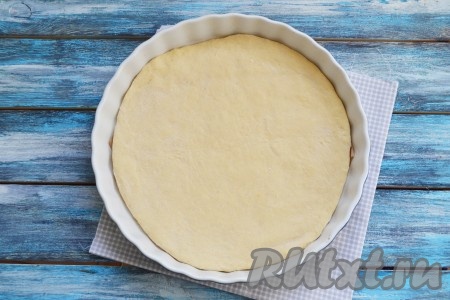Форму для выпечки смазать растительным маслом. Тесто разделить на 2 неравные части. Большую часть теста раскатать по диаметру вашей формы и застелить им дно. Толщину теста каждый регулирует под свой вкус: любите больше теста - раскатывайте тесто толщиной в 6-7 мм.
