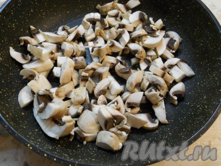 Шампиньоны, нарезанные небольшими кусочками, поместить в сковороду с растительным маслом, обжарить минуты 3-4, затем добавить очищенный нарезанный репчатый лук. Обжаривать все вместе еще минуты 3-4, затем остудить.
