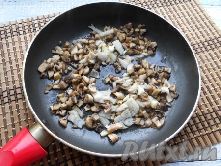 Обжарить грибы на небольшом огне, помешивая, в течение 4-5 минут, после чего добавить мелко нарезанный репчатый лук.
