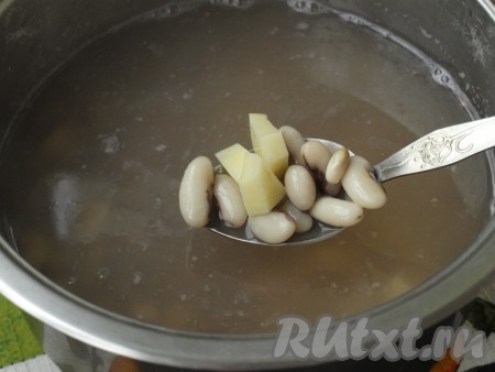 На следующий день фасоль промыть, переложить в кастрюлю и залить 2 литрами чистой воды. Варить фасоль до полуготовности (продолжительность варки до полуготовности зависит от сорта фасоли, это может занять от 15-20 минут и более). Очистить и нарезать кубиками картофель, добавить к фасоли и варить 10 минут.