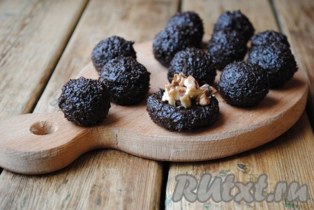 Каждый шарик прижать, чтобы получилась лепёшка, на которую выложить часть грецких орехов. Снова скатать шарик, чтобы орехи оказались внутри.