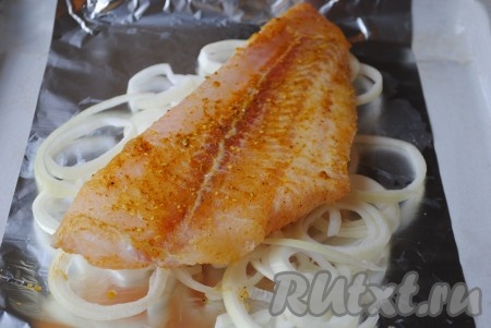 Если филе пангасиуса замороженное, его надо разморозить, обмыть и обсушить. Натереть филе солью, приправой к рыбе со всех сторон и выложить на луковую подушку.&nbsp;
