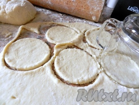 Замешанное тесто разделить на несколько частей. Затем одну часть теста на присыпанной мукой поверхности раскатать достаточно тонко. Стаканом врезать кружки из раскатанного теста.