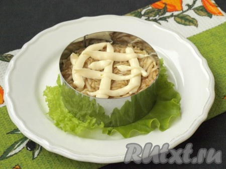 Яблоко тщательно вымыть, очистить от шкурки, затем натереть на тёрке в небольшую пиалу, смешать с лимонным соком. Выложить яблоко на нарезанное куриное мясо, смазать майонезом.
