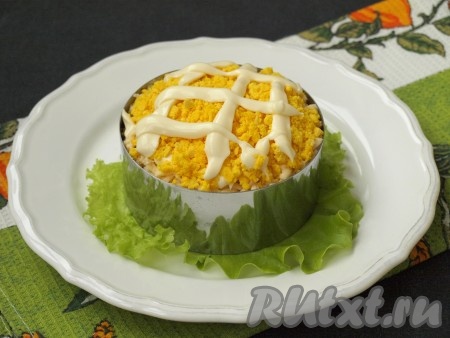 Яйца разделить на желтки и белки, натереть их по отдельности. Сначала выложить желтки, смазать майонезом.
