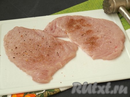 Мясо выложить на досочку и хорошо отбить с помощью кухонного молотка, прикрыв пищевой плёнкой. Посыпать мясо солью, приправой для птицы и перцем по вкусу.