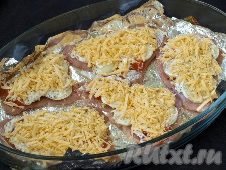Далее немного смазать отбивные сметаной и посыпать натёртым сыром.
