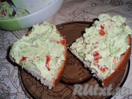 На кусочки хлеба выложить свежеприготовленную пасту из авокадо со сливочным сыром и подать к столу.
