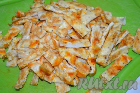 Остывшие яичные блинчики нарезать соломкой.