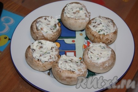 Шляпки грибов нафаршировать получившейся сырной массой.
