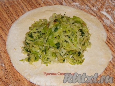 Разделить тесто на 5 равных кусочков. На столе, присыпанном мукой, каждую часть теста раскатать в лепешку диаметром около 10 см, в центр выложить часть капусты.
