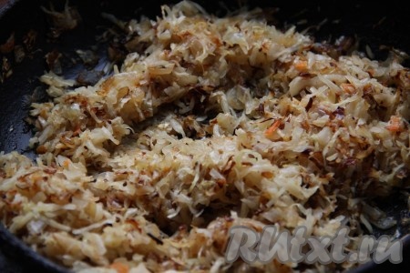 На сковороде разогреть растительное масло, выложить мелко нарезанный лук и обжарить, периодически помешивая, на небольшом огне до золотистого цвета. Капусту мелко нарезать и добавить к обжаренному луку, тушить капусту на среднем огне, около 15 минут, иногда помешивая.