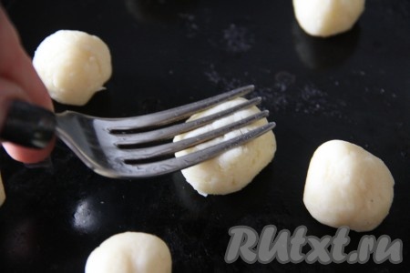 Прижать вилкой каждый шарик из теста.
