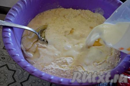 Молоко подогреть до тёплого состояния. Вливать молоко небольшими порциями в тесто, перемешивая тесто столовой ложкой. Температура молока не должна превышать 40 градусов, иначе дрожжи погибнут и тесто в дальнейшем не поднимется.