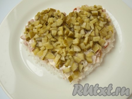 Нанести на курицу майонез и далее выложить нарезанный кубиками маринованный огурец.
