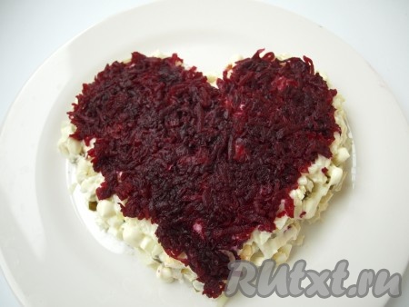 Свеклу, натерев на тёрке, выложить поверх лука. Затем широким ножом подровнять стороны сердца, придавая красивую форму.