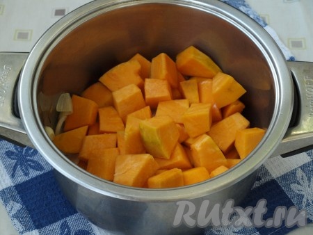 800 грамм очищенной тыквы нарезать на средние кубики, выложить в кастрюлю, перемешать с луком и чесноком, обжарить в течение 2-3 минут.