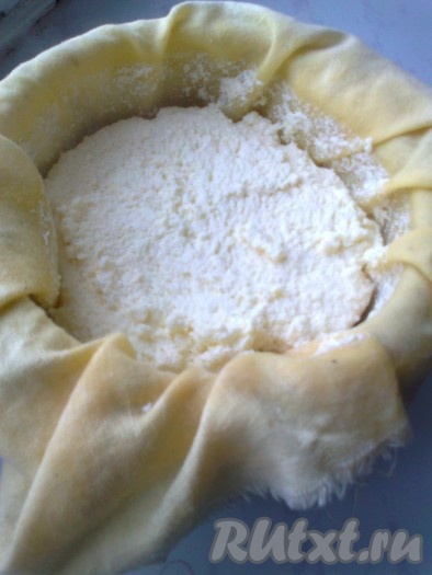 Творог должен разморозиться. Дуршлаг застилаем полотном или марлей, сложенной в несколько слоев, ставим его в подходящую посуду (кастрюлю) и выливаем в него творог с водой. Даем стечь воде в течение 15-20 минут. Воду, которая стекла, можно использовать для приготовления блинов, оладий, для выпечки хлеба, то есть там, где нужно использовать кислое молоко.
