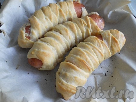 Запекать сосиски в разогретой духовке при температуре 200 градусов до румяности (в течение 15-20 минут).