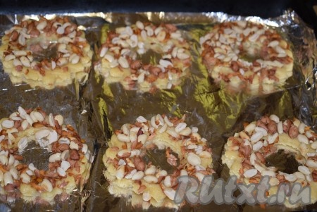 Песочные кольца стороной, смазанной яйцом, опускаем в обжаренный и дроблёный арахис. Выкладываем кольца на противень, застеленный фольгой (или пергаментом), и выпекаем печенье в разогретой до 190 градусов духовке, примерно, 12-15 минут.