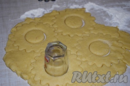 В серединке колец делаем рюмкой&nbsp;отверстие. Лишнее тесто убираем, остатки теста собираем в ком, раскатываем и тоже вырезаем заготовки песочного печенья "Кольцо".