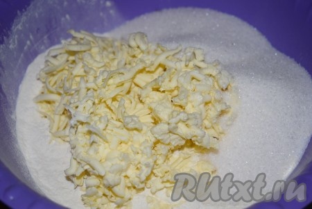 Насыпаем в миску 2 стакана муки, сахар, соль, соду. Сюда же достаём из холодильника и натираем на крупной тёрке сливочное масло.