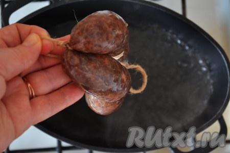 В кастрюлю влить воду, поставить на огонь, после закипания воды выложить колбасу.&nbsp;
