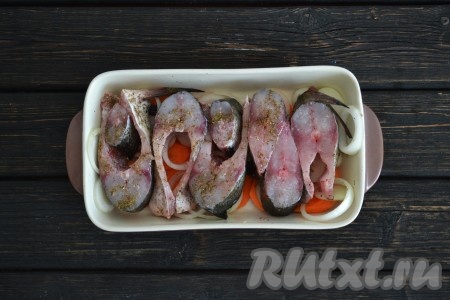 Плотно друг к другу выложить рыбные стейки сверху на овощи. 