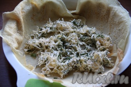 3 небольшие формы для выпечки (или порционные формочки) перед выкладыванием блинов можно смазать маслом. Каждую форму застилаем блином (у меня блины были очень маленького диаметра и я взяла по 2 блина на порцию). На середину блина выкладываем треть сырной массы и распределяем по блину. В центре начинки делаем маленькое углубление для яйца.