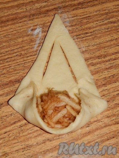 Свернуть рогалики. Я сворачиваю рогалики немного по-своему: для того чтобы из краев рогалика не вытекала начинка при выпечке, сначала подворачиваю края (как на фото), а уж потом сворачиваю рогалик и обваливаю в сахаре.