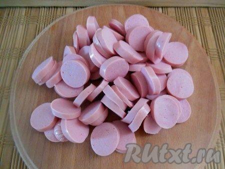 Сосиски очистите от оболочки и нарежьте на колечки.
