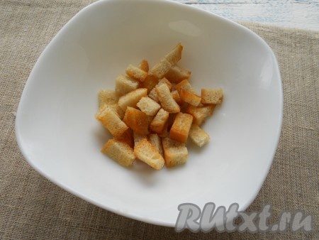 Сбрызнуть кусочки батона растительным маслом и обжарить на среднем огне на разогретой сковороде до румяности со всех сторон. Дать сухарикам остыть.
