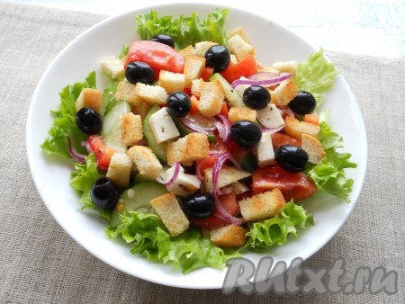 Сухарики и оливки разместить поверх греческого салата.
