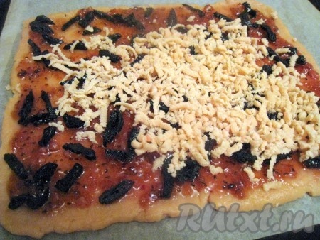 Достать из морозилки кусок теста и с помощью тёрки натереть его равномерно на начинку из варенья и чернослива.
