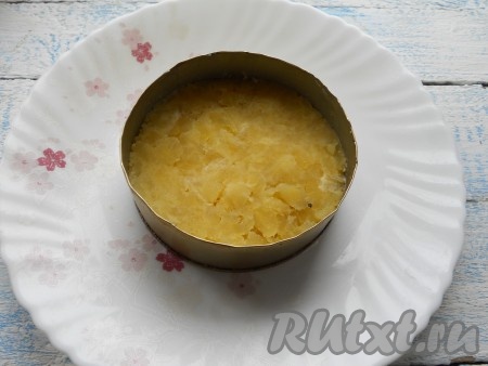 Салат лучше выкладывать на плоскую тарелку с помощью круглых кулинарных колец разной формы. Первым слоем выложить натертый на крупной терке картофель в большее по диаметру кольцо, чуть посолить.