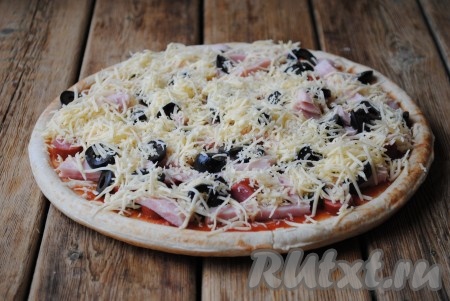 Сыр натереть на тёрке и щедро присыпать пиццу сверху.&nbsp;
