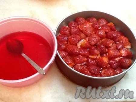 Достаем из холодильника форму с застывшим кремом и выкладываем клубнику поверх крема.
