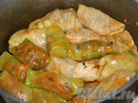 Плотненько укладываем голубцы в казан или толстостенную кастрюлю, заливаем кипятком, смешанным с томатной пастой и сметаной. Солим и перчим.&nbsp;
