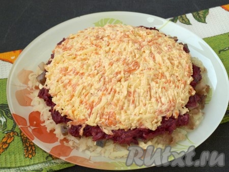На отдельную тарелочку натереть очищенную морковь и сыр, перемешать с майонезом, а затем выложить сверху свекольного слоя.