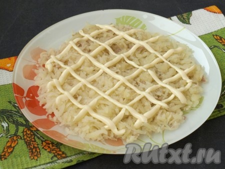 Отварной очищенный картофель натереть на тёрке и выложить первым слоем, нанести майонезную сетку.