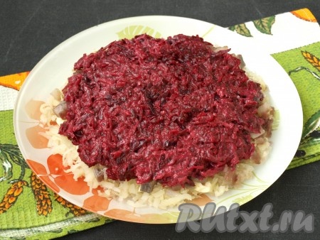 На отдельную тарелку натереть очищенную свеклу, выдавить чеснок, добавить майонез и перемешать. Получившуюся свекольную массу выложить поверх сельди.