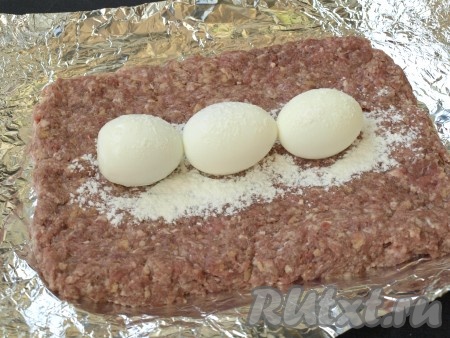 Варёные яйца очистить и выложить в ряд по центру, немного присыпать сверху мукой для фиксации.
