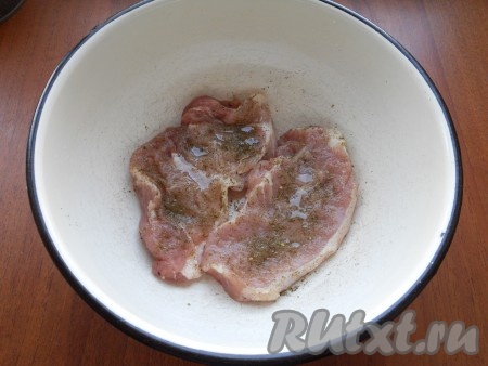 Натереть стейки сухими ароматными травами, специями для свинины, посолить, полить лимонным соком и 1 чайной ложкой растительного масла, оставить мясо для маринования на 2 часа в прохладном месте.
