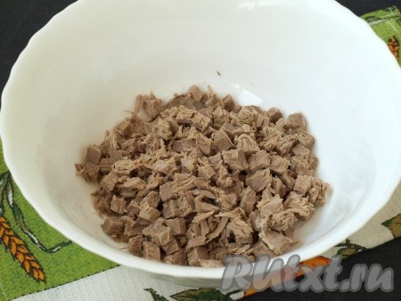 Заранее сваренную говядину нарезать кубиками и сложить в глубокую миску.