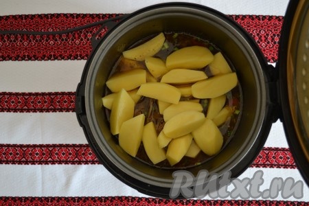 Очищенный картофель разрезать на 4 части (можно и мельче) и выложить к мясу.
